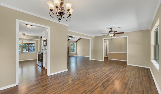 unfurnished room featuring ceiling fan with notable chandelier, a healthy amount of sunlight, dark hardwood / wood-style flooring, and crown molding