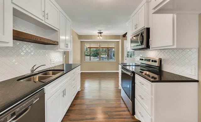 kitchen with sink, dark wood-type flooring, tasteful backsplash, white cabinets, and appliances with stainless steel finishes