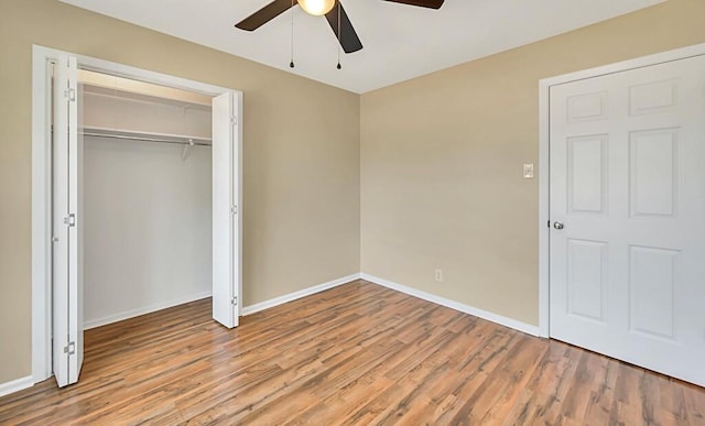 unfurnished bedroom featuring hardwood / wood-style floors, a closet, and ceiling fan