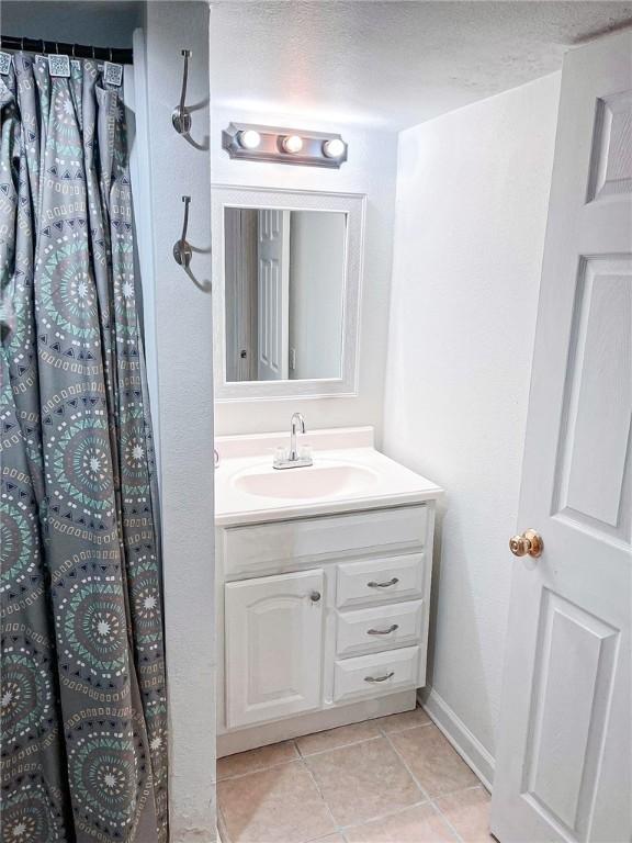 bathroom featuring a shower with curtain, vanity, tile patterned flooring, and a textured ceiling