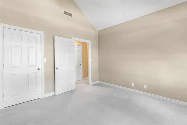 unfurnished bedroom with light carpet and high vaulted ceiling