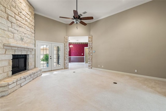 unfurnished living room with carpet floors, ornamental molding, high vaulted ceiling, and french doors