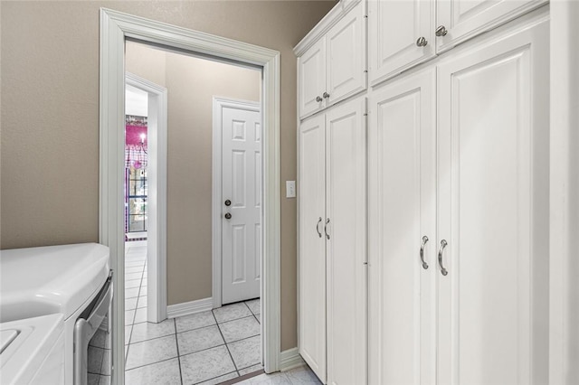 laundry area with cabinets, light tile patterned floors, and separate washer and dryer