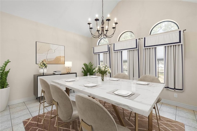 dining area featuring light tile patterned floors, high vaulted ceiling, and an inviting chandelier