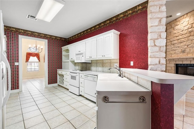 kitchen featuring white cabinetry, a notable chandelier, kitchen peninsula, white appliances, and light tile patterned flooring