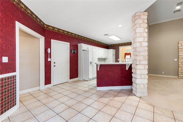 kitchen with kitchen peninsula, light colored carpet, crown molding, white cabinetry, and white fridge with ice dispenser