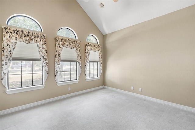 carpeted empty room featuring high vaulted ceiling