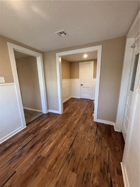 interior space with dark wood-type flooring and a textured ceiling