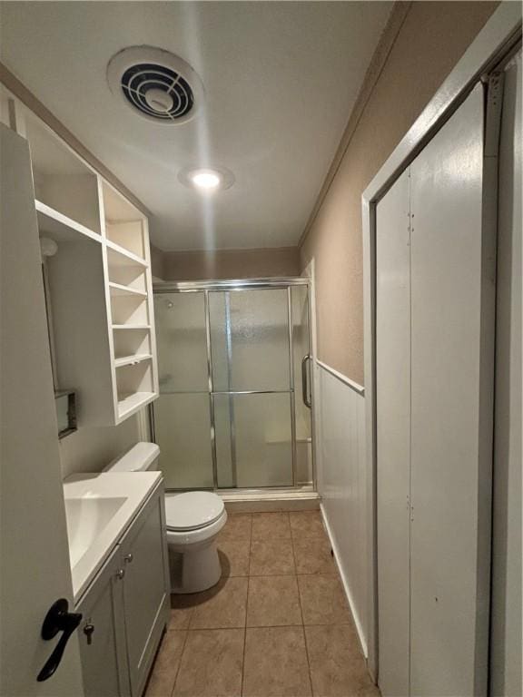 bathroom featuring an enclosed shower, vanity, tile patterned floors, and toilet