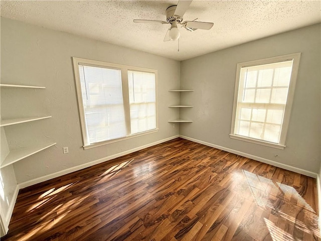 unfurnished room with dark hardwood / wood-style flooring, ceiling fan, and a textured ceiling