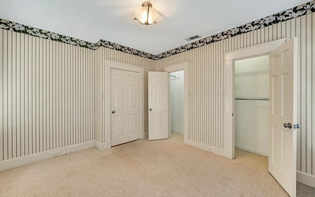 unfurnished bedroom with carpet floors, a closet, and a textured ceiling