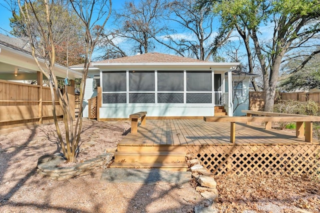 back of property featuring a sunroom and a deck