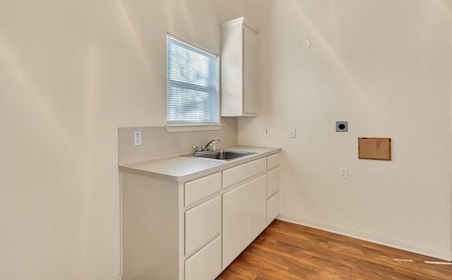 laundry area with hookup for an electric dryer, dark hardwood / wood-style flooring, and sink