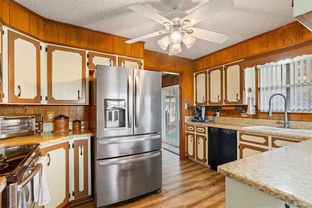 kitchen with sink, ceiling fan, a textured ceiling, light hardwood / wood-style floors, and stainless steel appliances