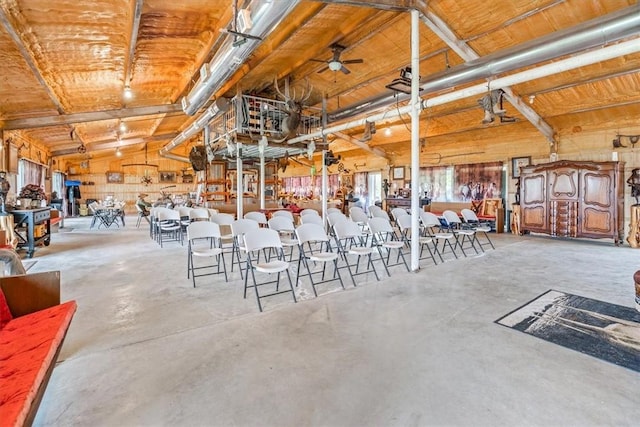 interior space with ceiling fan and wooden walls