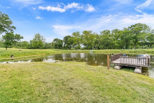 view of dock featuring a lawn and a water view