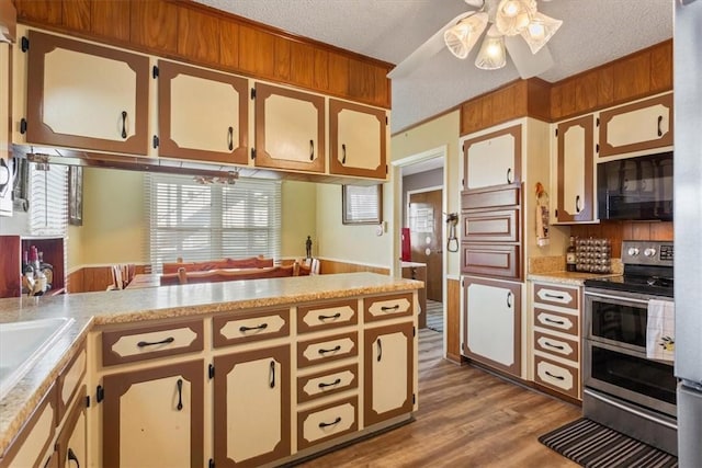 kitchen with electric range, ceiling fan, a textured ceiling, light hardwood / wood-style floors, and kitchen peninsula