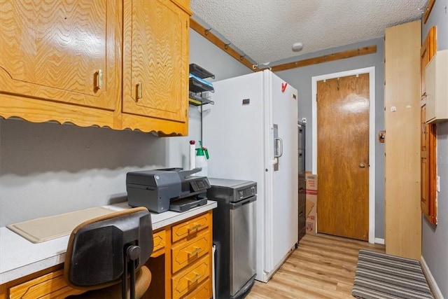 kitchen with light hardwood / wood-style floors and a textured ceiling