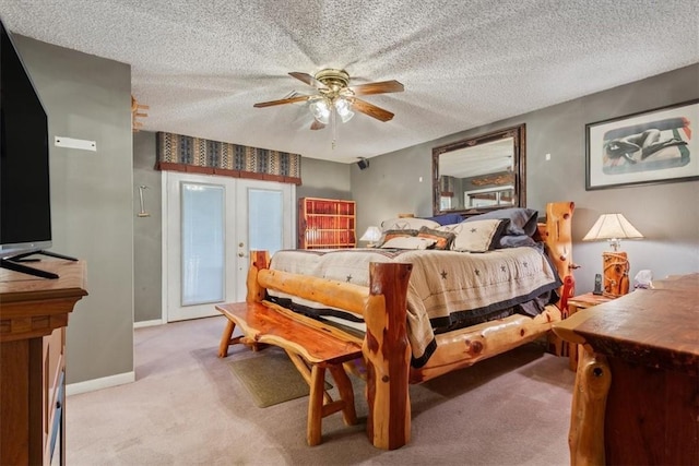 carpeted bedroom featuring ceiling fan, french doors, and a textured ceiling