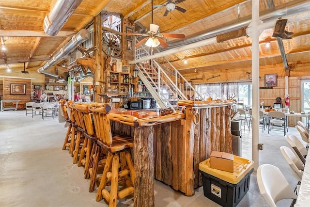 bar with vaulted ceiling with beams and ceiling fan