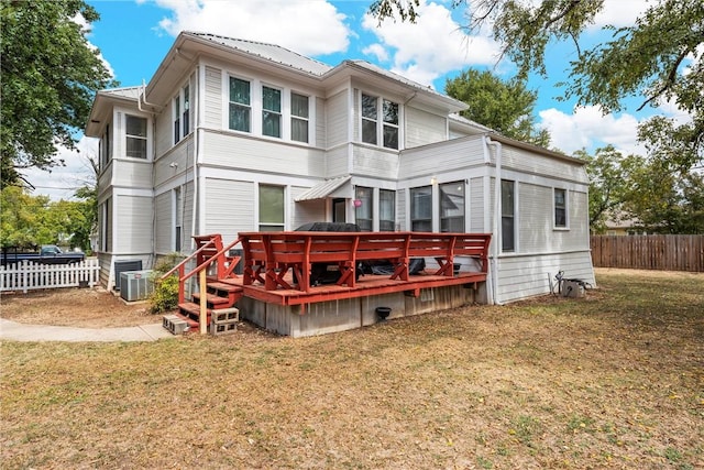 back of house featuring a lawn, a wooden deck, and central AC unit