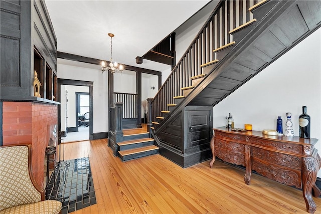 stairs featuring hardwood / wood-style flooring and a notable chandelier