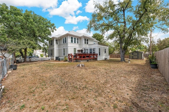 back of property featuring a storage unit and a deck