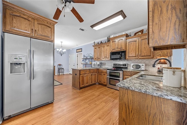 kitchen featuring sink, stainless steel appliances, light stone counters, light hardwood / wood-style flooring, and ornamental molding