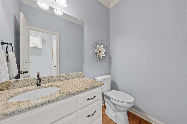 bathroom featuring vanity, toilet, wood-type flooring, and crown molding