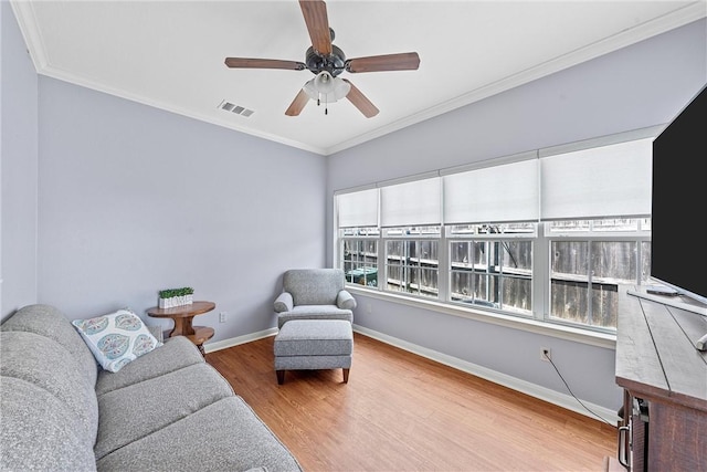 interior space with ceiling fan, wood-type flooring, and ornamental molding