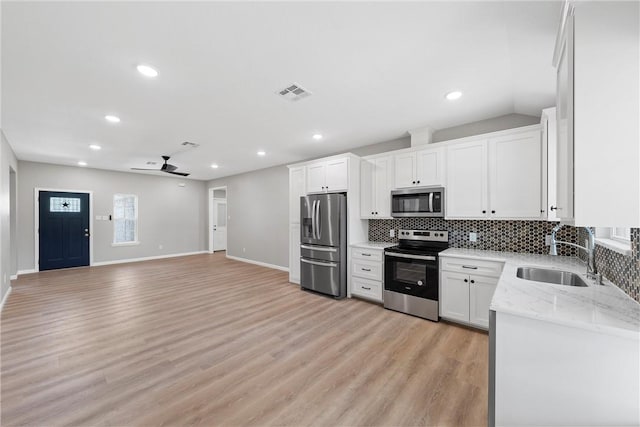 kitchen featuring light wood-type flooring, stainless steel appliances, ceiling fan, sink, and white cabinets