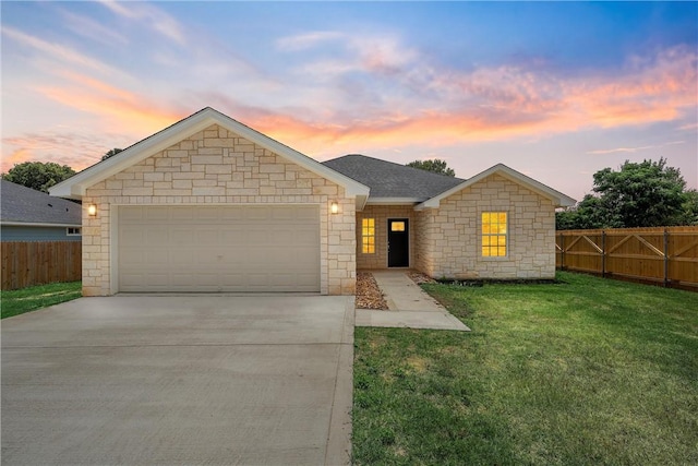 single story home featuring a garage and a lawn