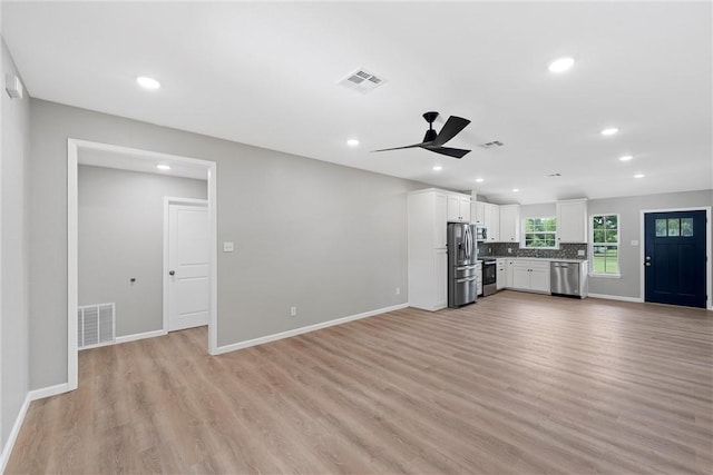 unfurnished living room featuring ceiling fan and light hardwood / wood-style flooring