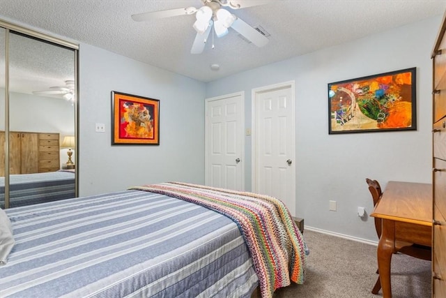 carpeted bedroom featuring ceiling fan and a textured ceiling