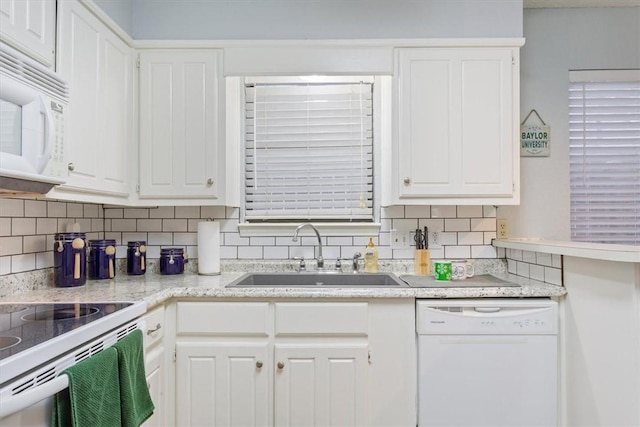 kitchen with backsplash, white cabinetry, white appliances, and sink