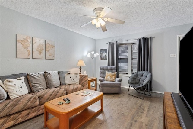 living room with ceiling fan, hardwood / wood-style floors, and a textured ceiling