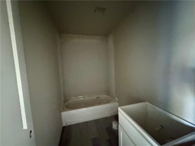 bathroom with vanity, hardwood / wood-style floors, and a tub to relax in