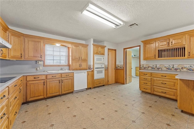 kitchen with white appliances, a textured ceiling, and sink