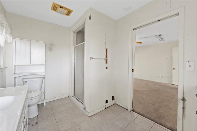 bathroom with a shower with door, tile patterned floors, vanity, and toilet