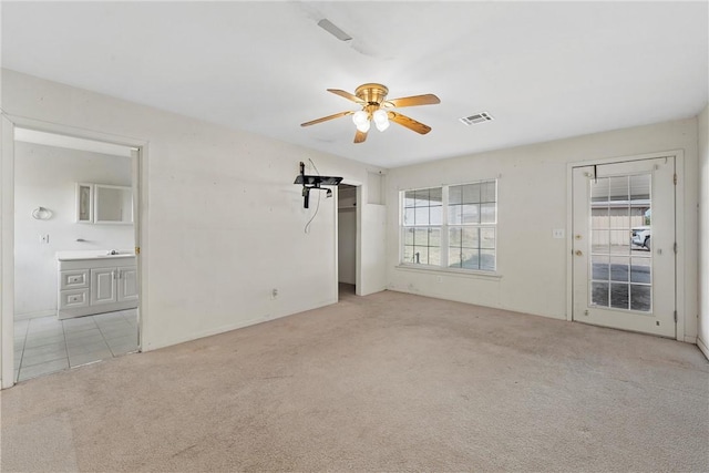 unfurnished room with light colored carpet and ceiling fan