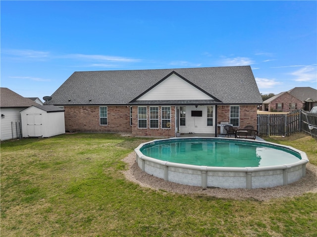 rear view of property with fence, an outdoor structure, a storage shed, a lawn, and brick siding