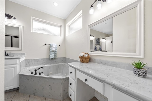 bathroom with tile patterned floors, a jetted tub, and vanity