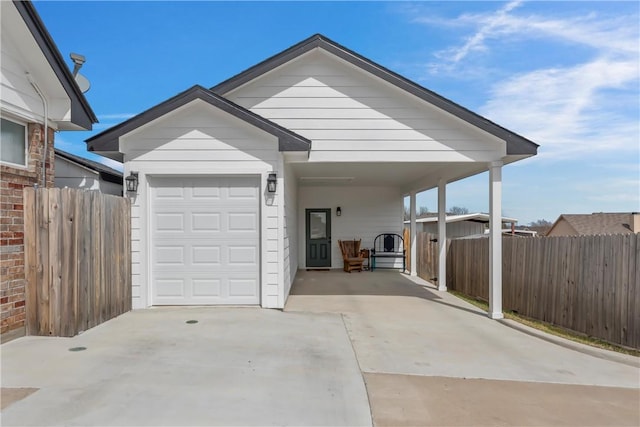 garage with a carport, fence, and driveway