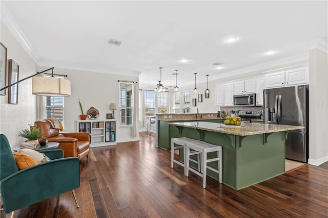 kitchen featuring visible vents, a breakfast bar, stainless steel appliances, a peninsula, and dark wood-style flooring