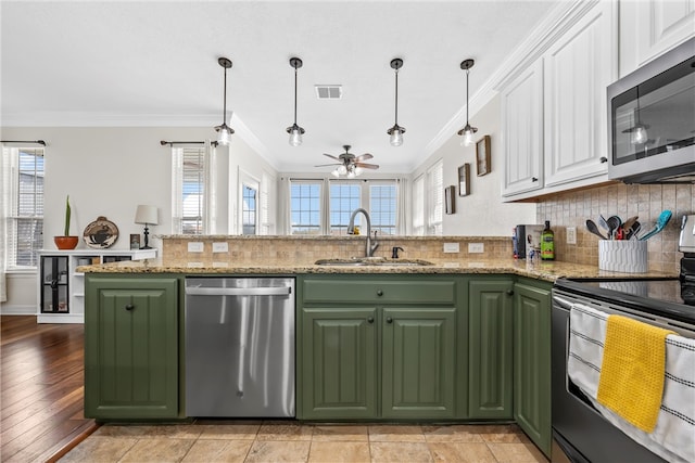 kitchen featuring green cabinets, a sink, white cabinetry, and stainless steel appliances