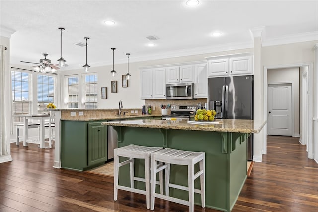 kitchen with green cabinets, a peninsula, stainless steel appliances, white cabinetry, and a ceiling fan