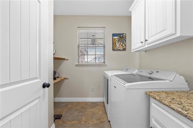 clothes washing area with cabinet space, washer and dryer, and baseboards