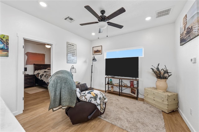 living area featuring light wood finished floors, visible vents, and a ceiling fan