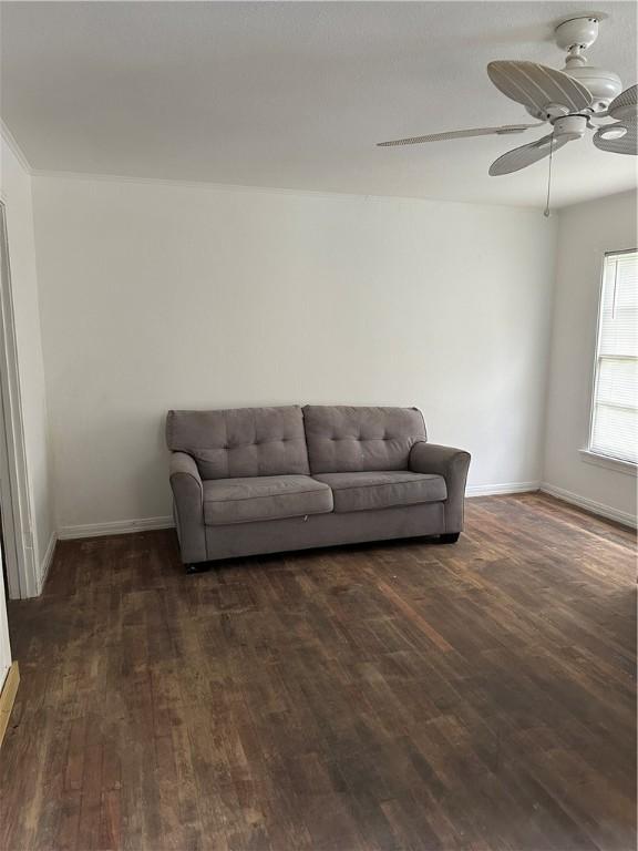 living room featuring ceiling fan and dark wood-type flooring