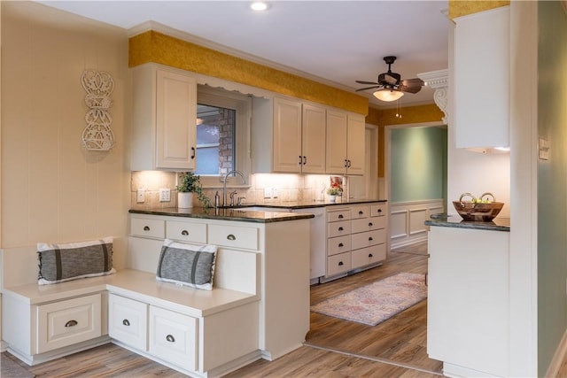 kitchen featuring ceiling fan, kitchen peninsula, white cabinets, and light wood-type flooring